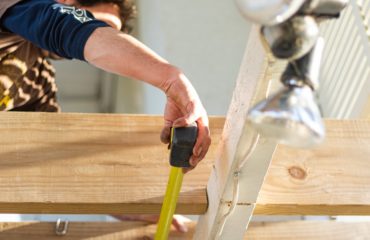 man measuring wood