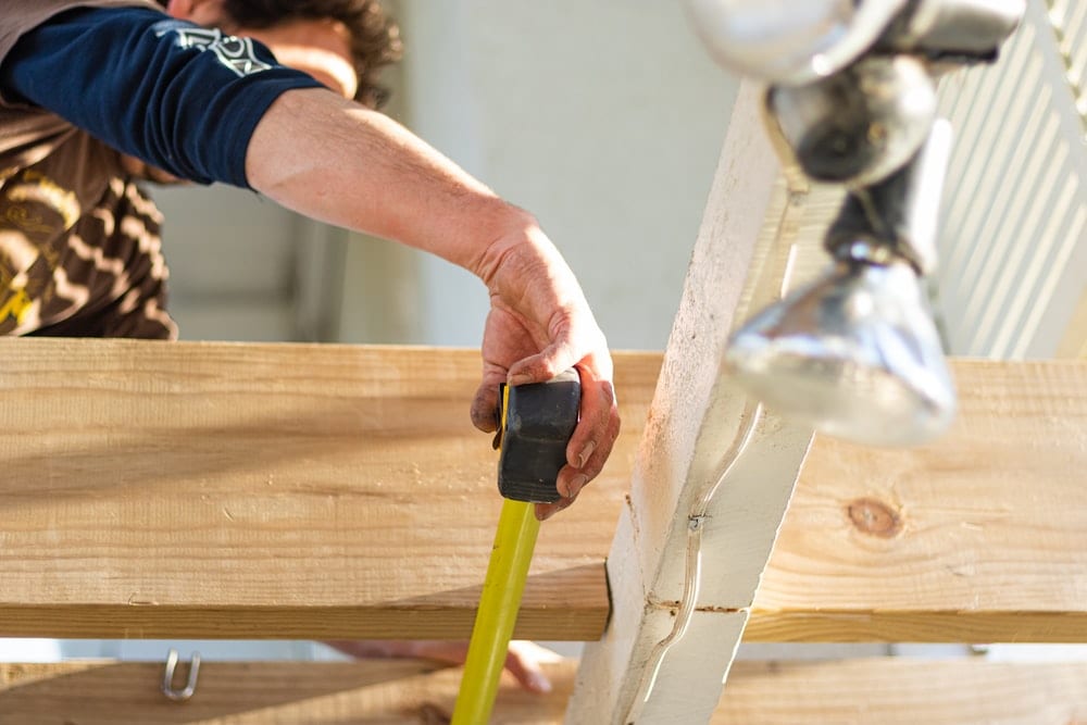 man measuring wood